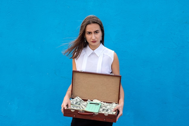 Biznes kobieta trzyma drewnianą walizkę pełny rachunek dolarów