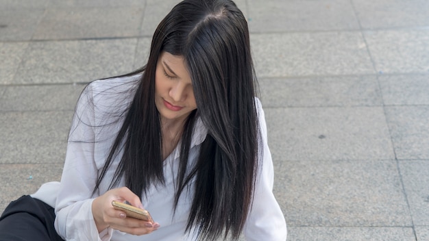 Zdjęcie biznes kobieta trzymać i patrzeć na inteligentny telefon