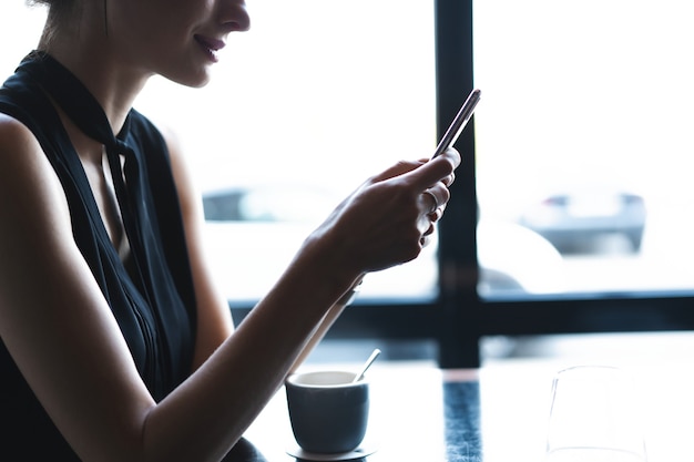 Biznes kobieta za pomocą smartfona podczas obiadu w kawiarni.