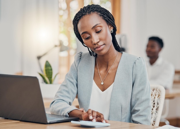 Biznes księgowy i czarna kobieta pisząca na kalkulatorze podczas pracy w sieci w biurze w pracy Afrykański księgowy pracujący i planujący finanse na laptopie dla finansowej firmy korporacyjnej