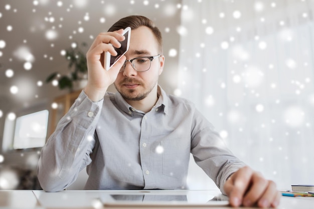 Zdjęcie biznes, stres, porażka, technologia i koncepcja ludzi - biznesmen lub kreatywny pracownik męski ze smartfonem w biurze domowym nad śniegiem