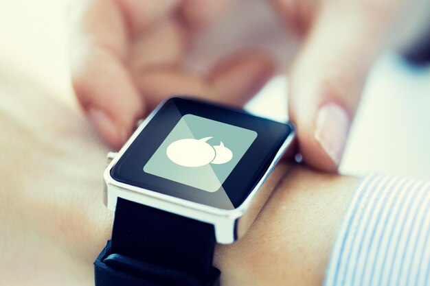biznes, technologia, komunikacja, połączenie i koncepcja ludzi - zbliżenie rąk z ikoną wiadomości na smartwatchu