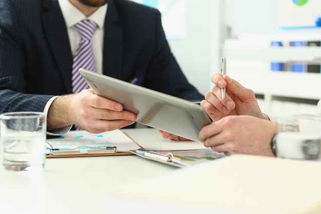 Biznesmen analizuje wykres za pomocą touchpada cyfrowego tabletu