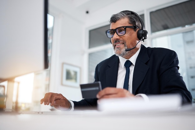 Biznesmen call center i karta kredytowa przy komputerze do telemarketingu finansowego e-commerce i zniżki w biurze Szczęśliwy konsultant dojrzały sprzedawca i handel z bankowością internetową na komputerze stacjonarnym