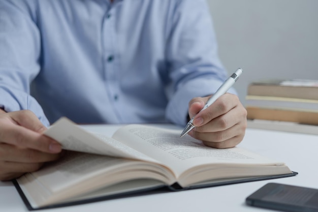 Biznesmen czytający i piszący na temat bookeducation studiujący rozwój wiedzy i koncepcję uczenia się poznania