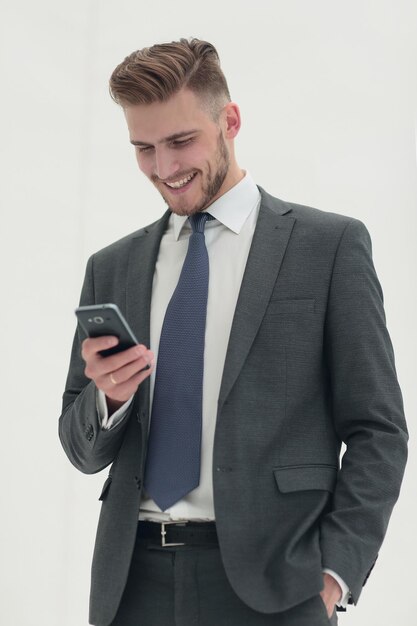Biznesmen czytający SMS na swoim smartfonie na białym tle