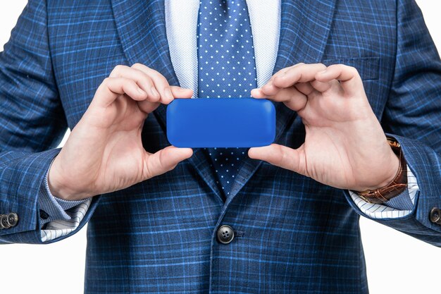 Biznesmen demonstruje nowoczesny gadżet udanego dyrektora generalnego trzymającego człowieka z niebieskim pudełkiem ze skórzanym pudełkiem przyciętym szefem w rzeczowym garniturze na białym tle na białą reklamę