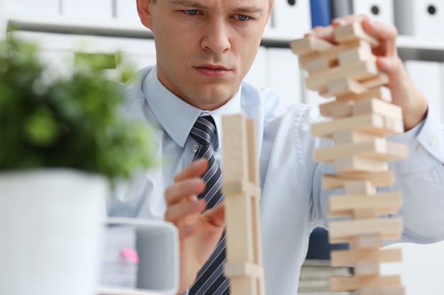 Zdjęcie biznesmen gra w strategię ręki jenga