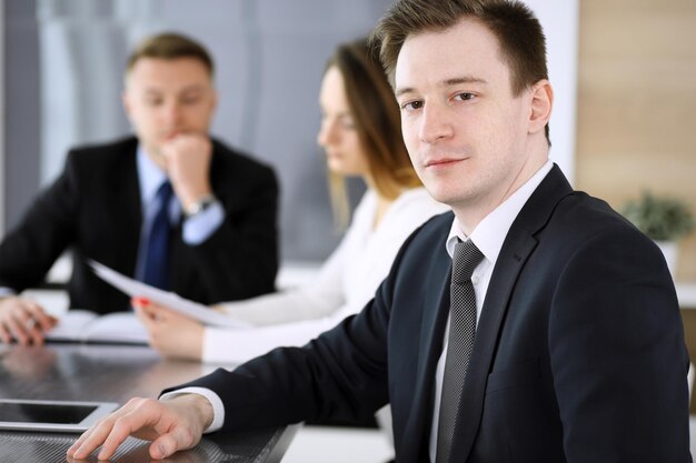 Zdjęcie biznesmen headshot na spotkaniu w nowoczesnym biurze nieznany przedsiębiorca siedzi z kolegami w tle koncepcja pracy zespołowej i partnerstwa