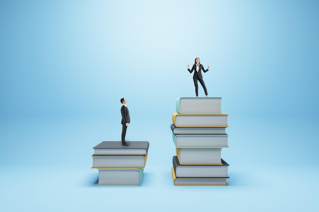 Biznesmen i kobieta stojąca na książkach na niebieskim tle Konkurencja koncepcja edukacji i wiedzy