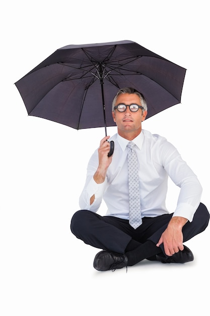 Biznesmen jest ubranym szkła osłania z parasolem