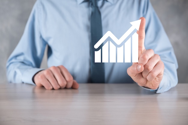 Biznesmen mężczyzna trzyma wykres z dodatnim wzrostem zysków. planuj wzrost wykresu i wzrost pozytywnych wskaźników wykresu