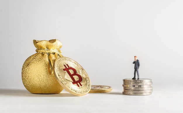 Biznesmen Miniaturowe Stojąc Na Monety I Patrząc Na Złoty Bitcoin