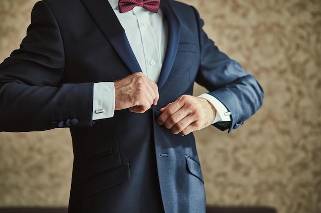 Zdjęcie biznesmen nosi kurtkęmężczyzna ręce zbliżenie pana młodego szykuje się rano przed ceremonią ślubną