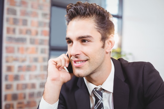 Biznesmen opowiada na telefonie komórkowym w biurze