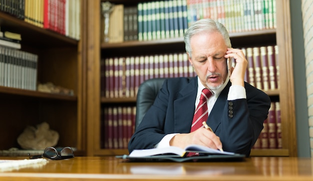 Zdjęcie biznesmen opowiada telefon w biurze