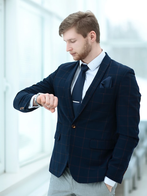 Biznesmen patrzący na zegarek w biurze