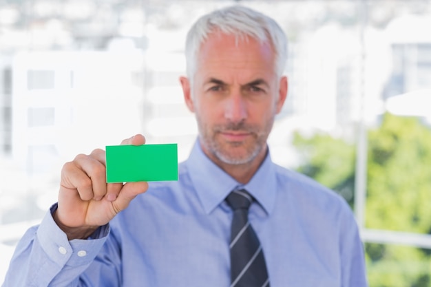 Zdjęcie biznesmen pokazuje zieloną wizytówkę