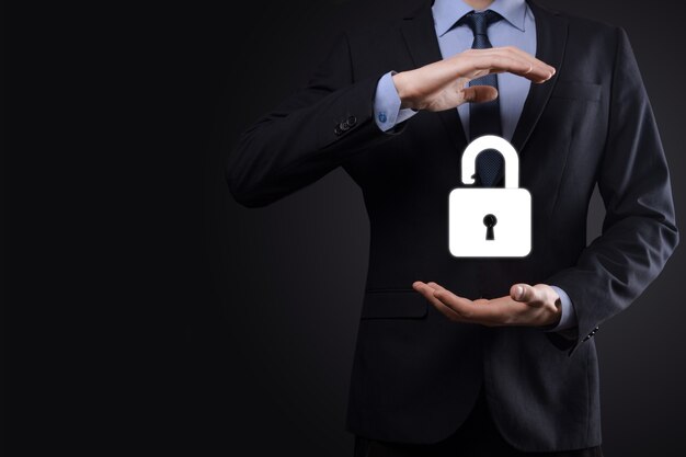 Biznesmen posiada ikonę otwartej kłódki na dłoni. Odblokowanie wirtualnej blokady. Koncepcja biznesowa i metafora technologii dla cyberataku, przestępczości komputerowej, bezpieczeństwa informacji i szyfrowania danych.