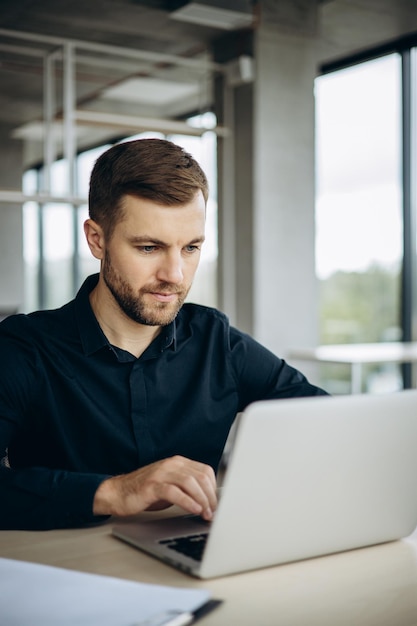 Biznesmen pracujący na laptopie przy biurku