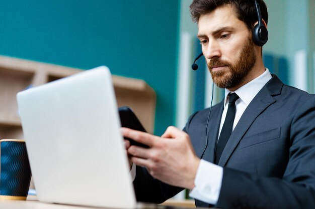 Biznesmen pracujący przy laptopie i telefonie online dla firmy zajmującej się obsługą klienta