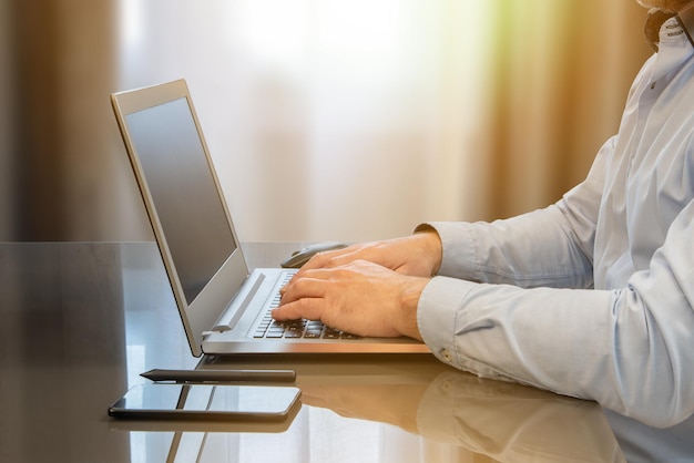 Biznesmen pracujący w domu i używający swojego laptopa Koncepcja telepracy