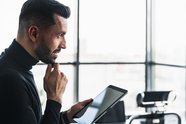 Biznesmen pracujący z tabletem i myślący o czymś