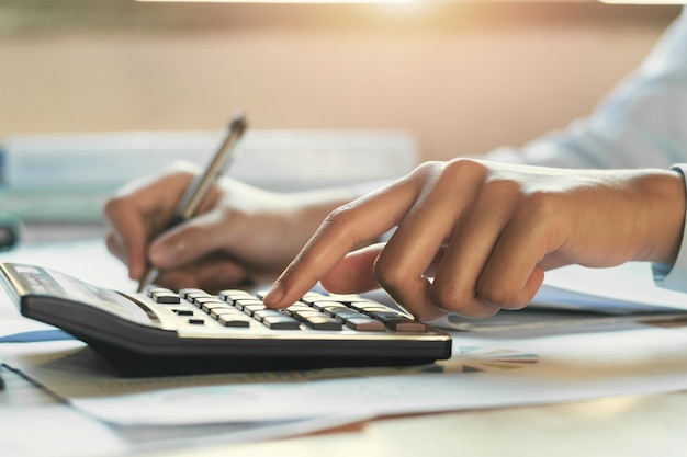 biznesmen pracuje na biurku przy użyciu kalkulatora, koncepcja rachunkowości finansowej