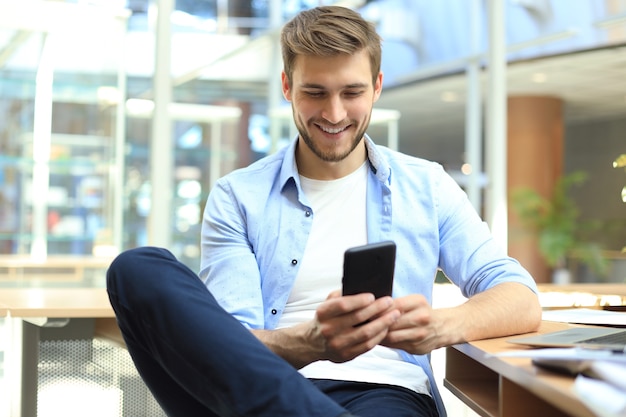 Biznesmen przy użyciu telefonu komórkowego w biurze.