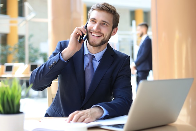 Biznesmen przy użyciu telefonu komórkowego w biurze.