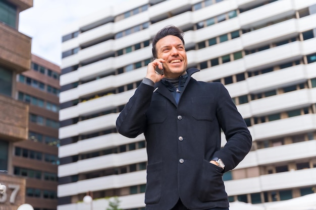 Biznesmen rasy kaukaskiej w średnim wieku rozmawia przez telefon w wezwaniu do pracy w mieście