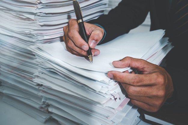 Biznesmen ręka leżał na papierze i pisać numer piórem