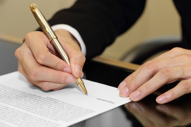 Biznesmen ręka podpisuje kontraktowego papier