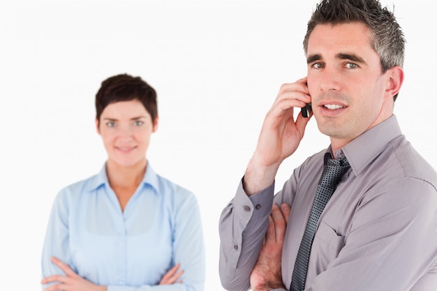 Biznesmen robi rozmowie telefonicza podczas gdy jego kolega pozuje