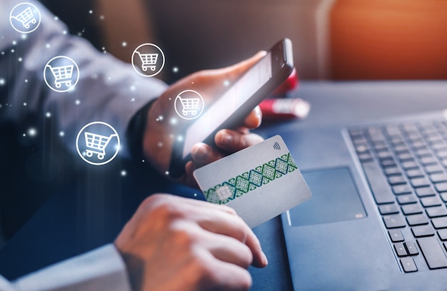 Biznesmen robi zakupy online za pomocą karty kredytowej i telefonu komórkowego.