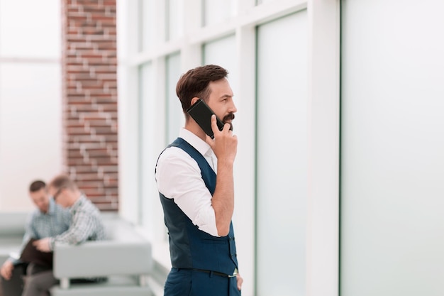 Biznesmen Rozmawia Przez Smartfon Stojąc W Biurze