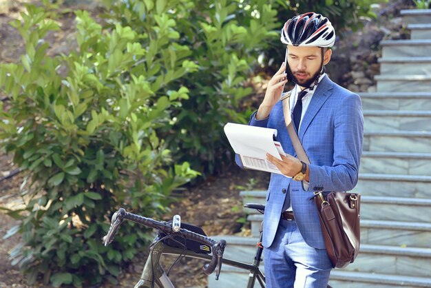 Biznesmen rozmawia przez telefon komórkowy i analizuje raport