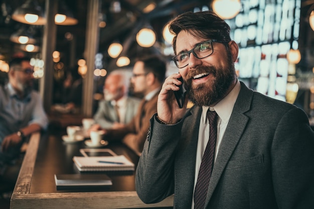 Biznesmen rozmawia przez telefon w pubie