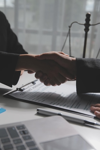 Biznesmen ściska dłoń, aby przypieczętować umowę z prawnikami lub prawnikami partnerskimi omawiającymi umowę kontraktową