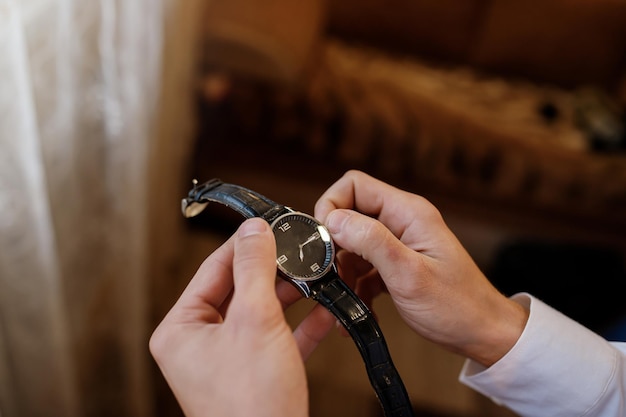 Biznesmen sprawdzanie czasu na jego zegarku na nadgarstek Mężczyzna oddanie zegara na rękę Pan młody szykuje się rano przed ceremonią ślubu Moda męska