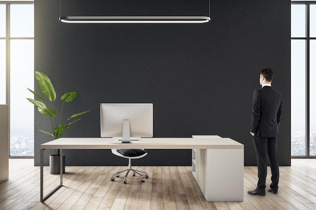 Biznesmen stojący w nowoczesnym wnętrzu biurowym z meblami i innymi przedmiotami CEO i koncepcja wykonawcza