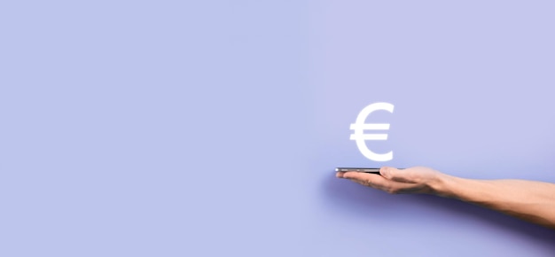 Biznesmen trzyma pieniądze monety ikony EUR lub Euro na ciemnym tleRozwijająca się koncepcja pieniędzy na inwestycje biznesowe i finanse