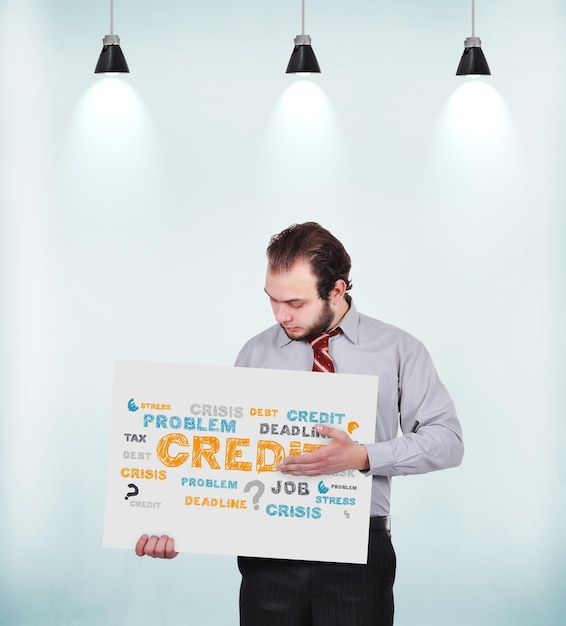 Biznesmen trzyma plakat z rysunkową koncepcją kredytową
