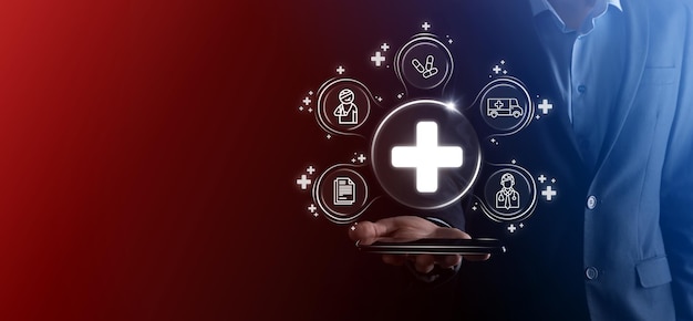Biznesmen trzyma wirtualne plus ikony połączenia z siecią medyczną Pandemia Covid19 rozwija świadomość ludzi i szerzenie uwagi na ich opiece zdrowotnej.