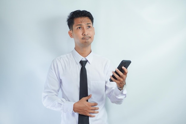 Zdjęcie biznesmen trzymający żołądek i telefon komórkowy myślący o zamówieniu jedzenia online zamówienie jedzenia online