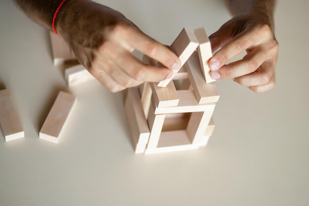 Biznesmen umieszczający drewniany klocek na koncepcji wieży kontrola ryzyka Planowanie i strategia w biznesieRóżnica wielkości modelu małych drewnianych domów