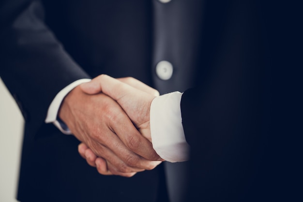 Zdjęcie biznesmen uścisnąć dłoń uzgadnia duże ilości sprzedaży, które kończą cel planów marketingowych firmy