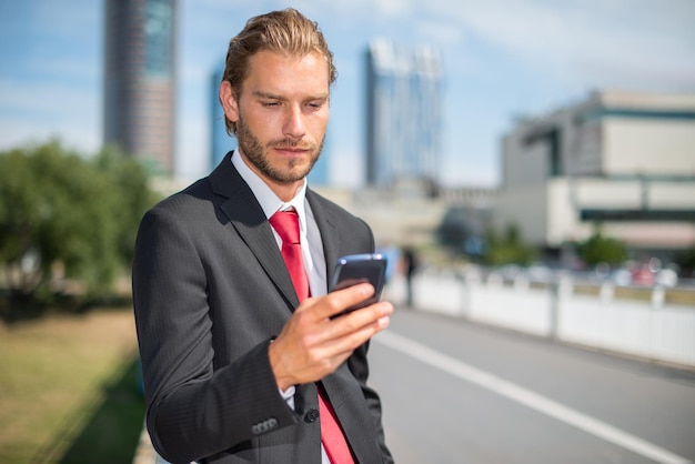 Biznesmen używa jego telefon komórkowego