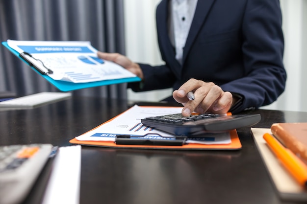 Zdjęcie biznesmen używa kalkulatora biznesowej kalkulaci pieniężnego.