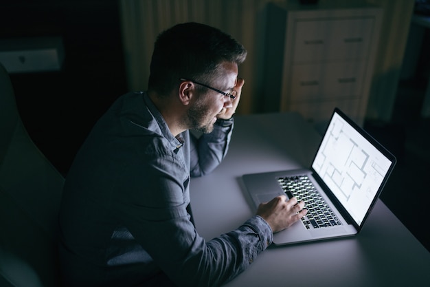 Biznesmen Używa Laptop I Siedzący W Biurze Póżno Przy Nocą.